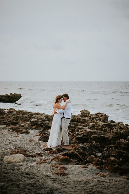 Coral Cove beach elopement wedding couple embrace on rocky beach
