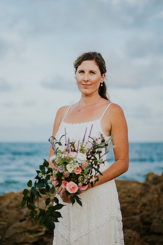 Coral Cove beach elopement bridal portrait in white lace beach wedding dress holding bouquet