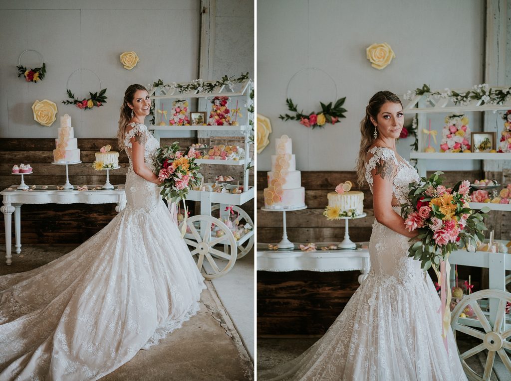 Bride posing in front of wedding cake and dessert buffet cart for Pink Lemonade photoshoot barn wedding at Twisted Oak Farm in Vero Beach FL
