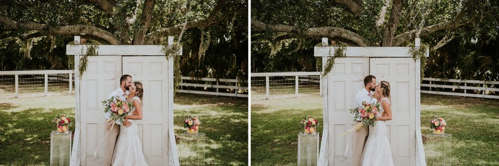 Bride and Groom kissing and laughing in front of ceremony wedding door under oak tree at Pink Lemonade photoshoot Twisted Oak Farm Vero Beach FL barn wedding