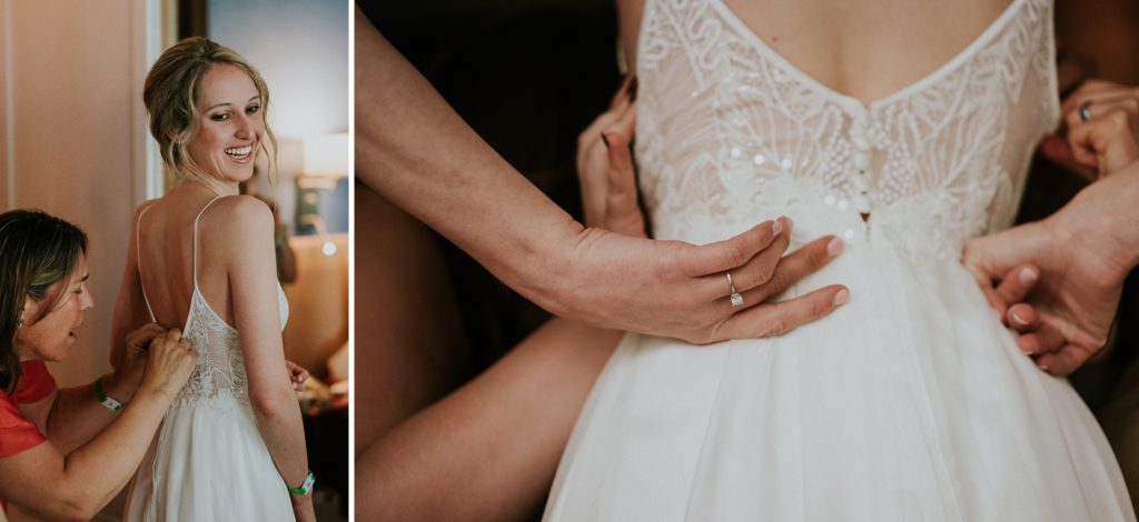 Mother of the bride helps put on bride's dress with a close up of her engagement ring