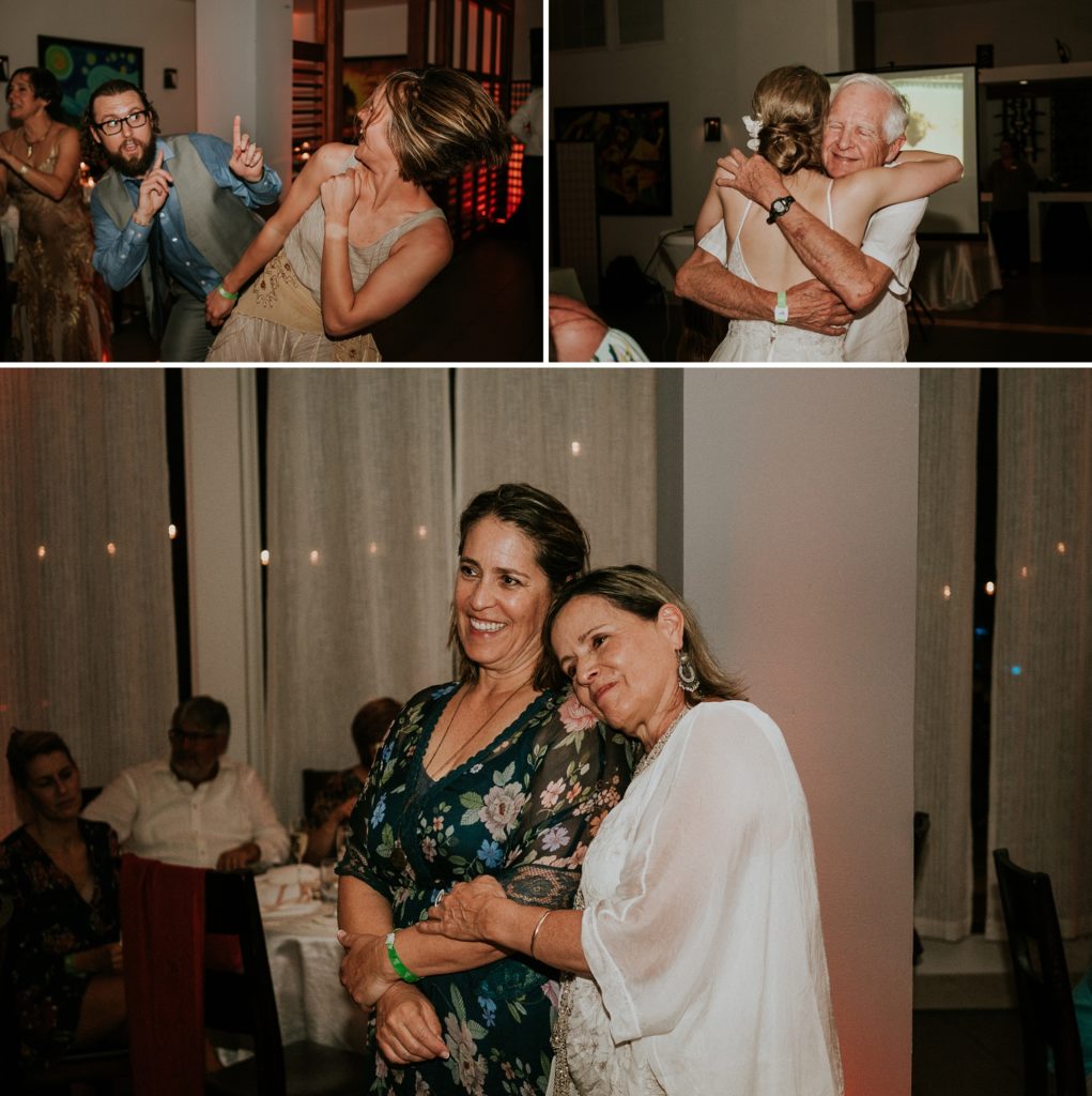 Mother of the bride and her aunt watch reception dancing and the father of the bride hugging his daughter the bride