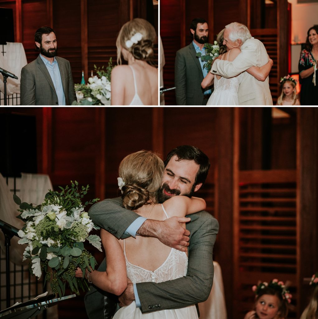 Groom sees bride for first time, bride's father gives her away and hugs her, and groom hugs his bride in indoor ceremony at Club Med Sandpiper Bay