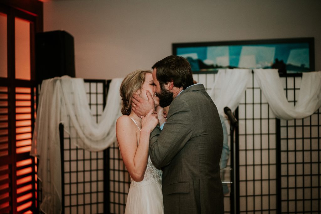 First kiss as husband and wife indoor ceremony rainy wedding day
