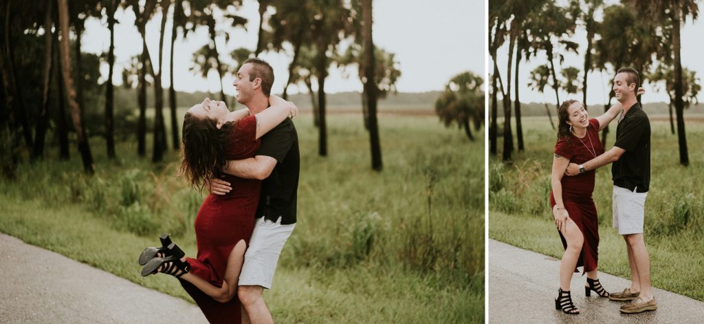 Man lifts woman up in the air and they laugh in the rain during engagement photos at Myakka river state park