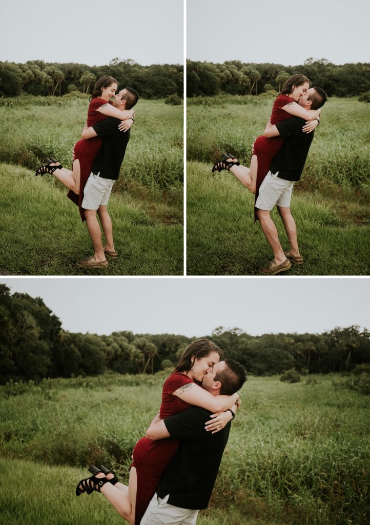 Man lifts woman up in the air to kiss in the rain during engagement photos at Myakka river state park