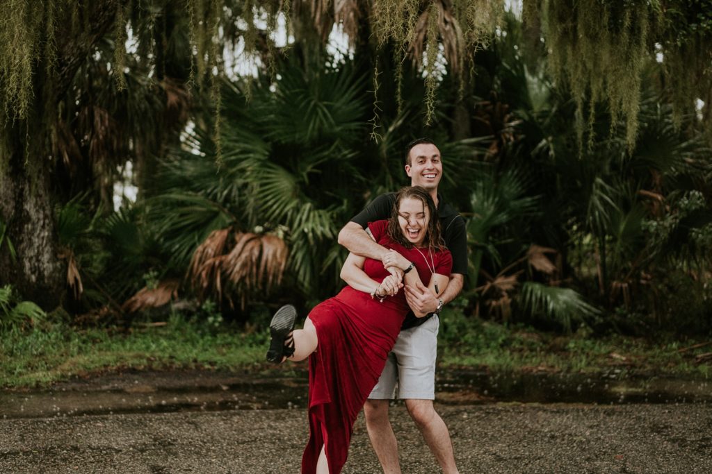 Sarasota wedding couple dancing and laughing in the rain for engagement photos at Myakka River state park