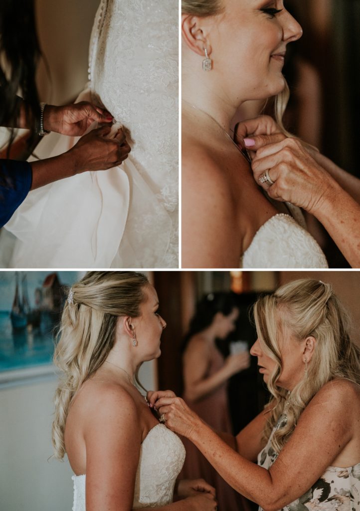 Mom fixes bride's necklace and wedding coordinator bustles her dress