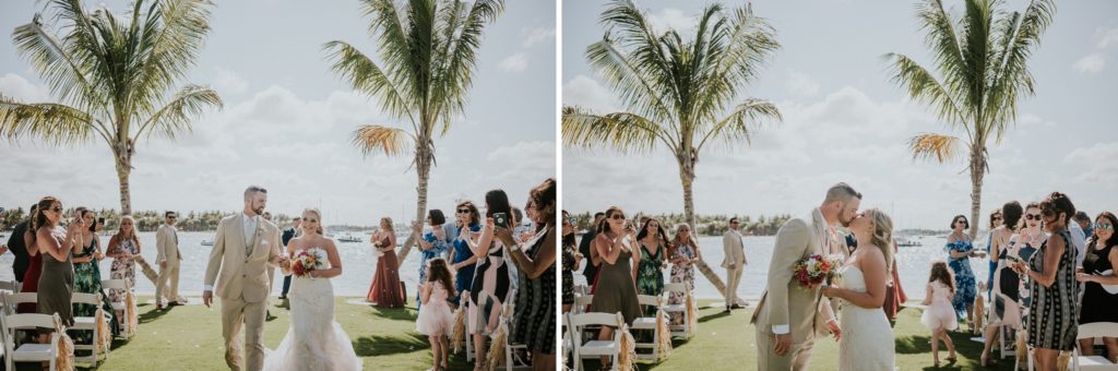 Bride and groom walk down aisle and kiss with palm trees in the background at Sailfish Marina Singer Island FL destination wedding