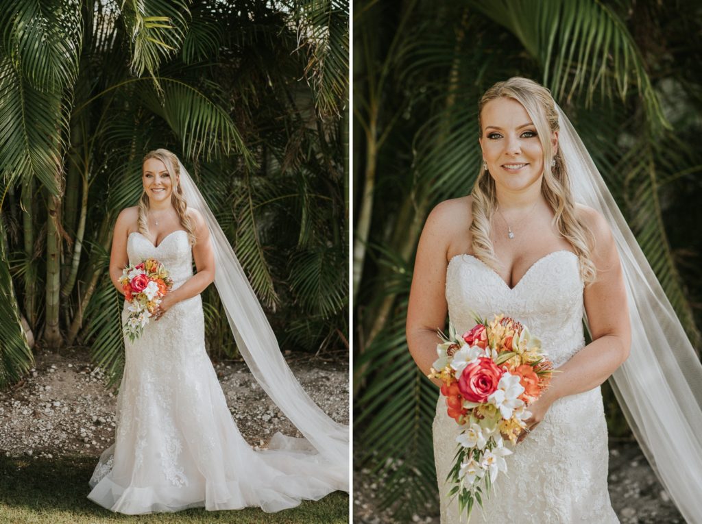 Bride in long cathedral veil with tropical wedding bouquet in front of bamboo and palms at Sailfish Marina wedding in Singer Island