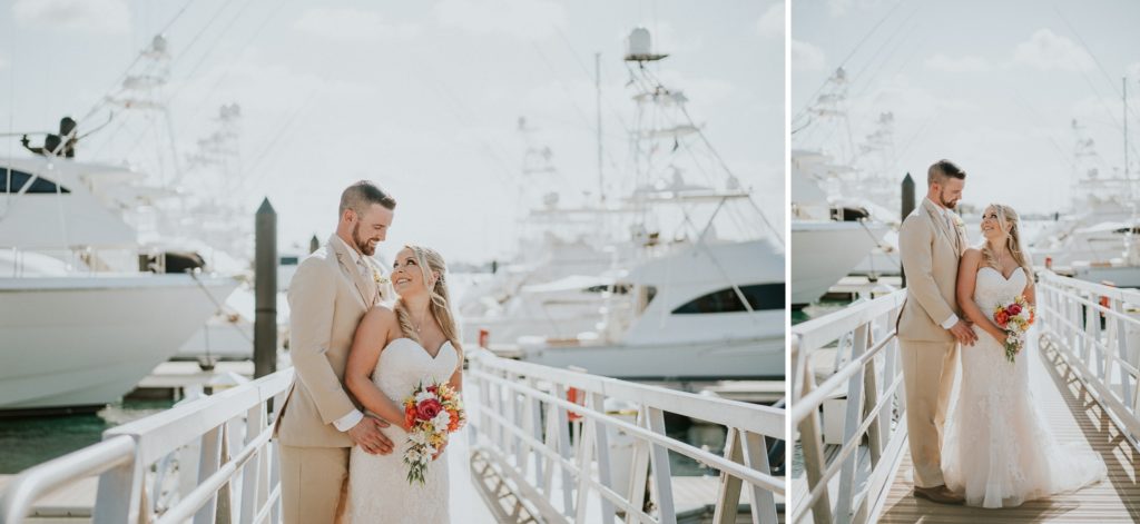 Bride and groom look at each other on docks of Sailfish Marina for their small coastal Florida destination wedding on Singer Island with boats