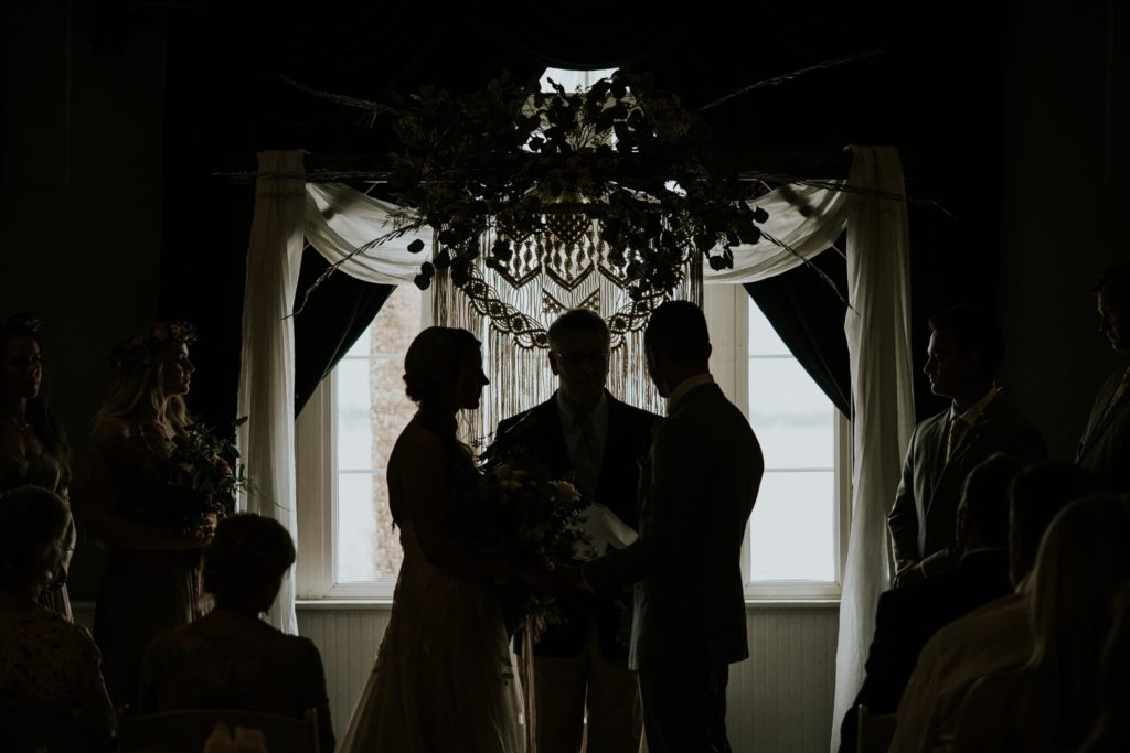 Silhouette of bride, officiant, and groom at their indoor wedding ceremony at Flagler Place in Downtown Stuart FL