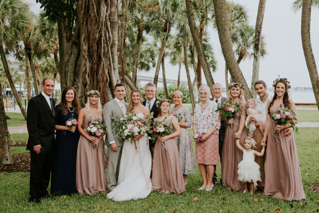 Family photo in front of large tree covered with vines and roots at Downtown Stuart Flagler Place wedding