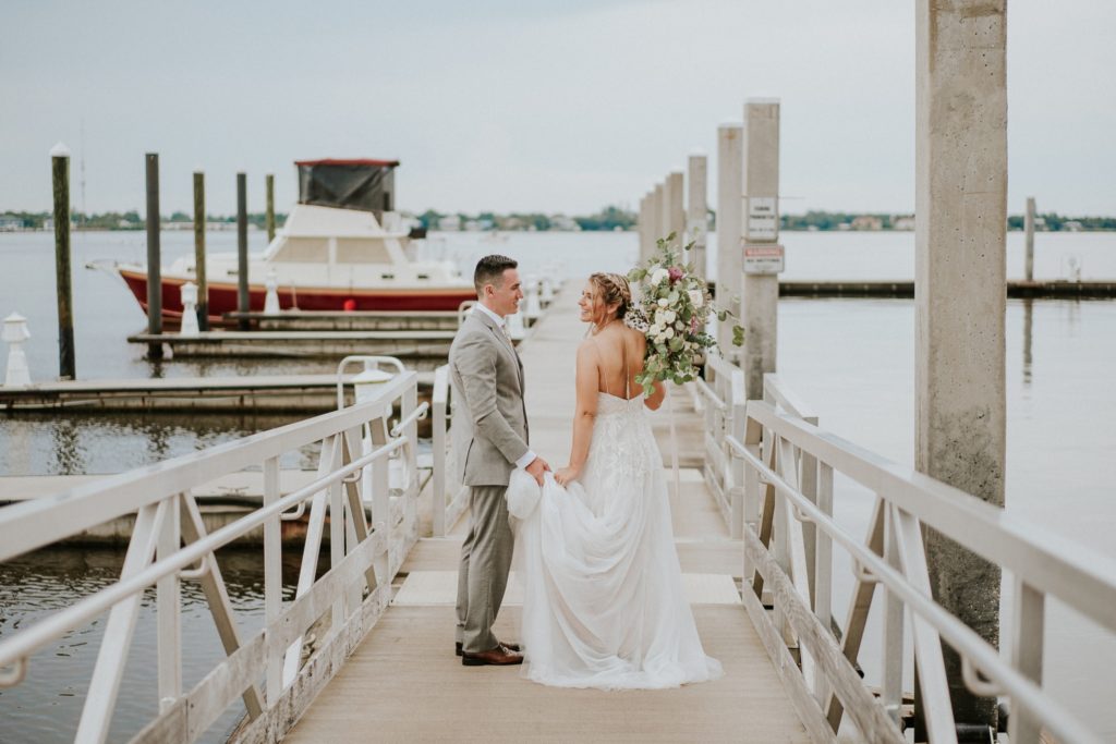 Bride and groom look at each other on boat docks in Downtown Stuart FL Riverwalk