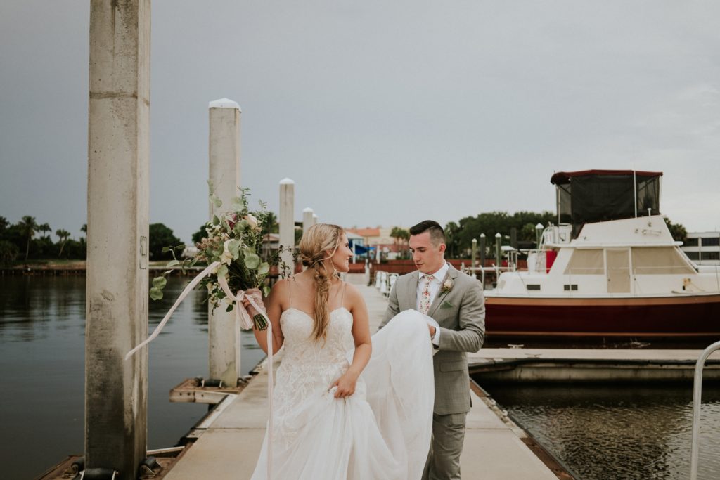 Bride and groom walk along boat docks for Downtown Stuart Florida elopement