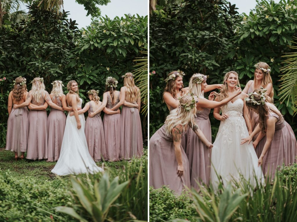 Bride looks over her shoulder with bridesmaids linking arms and they fix bride's dress