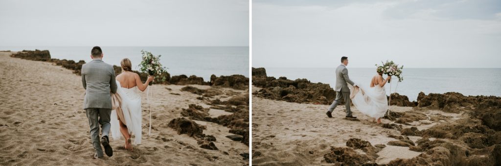 Groom holds bride's dress and they walk rocky beach for House of Refuge elopement