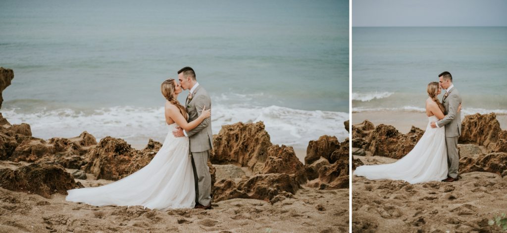 Wedding couple kiss on rocky beach with water behind them at House of Refuge elopement