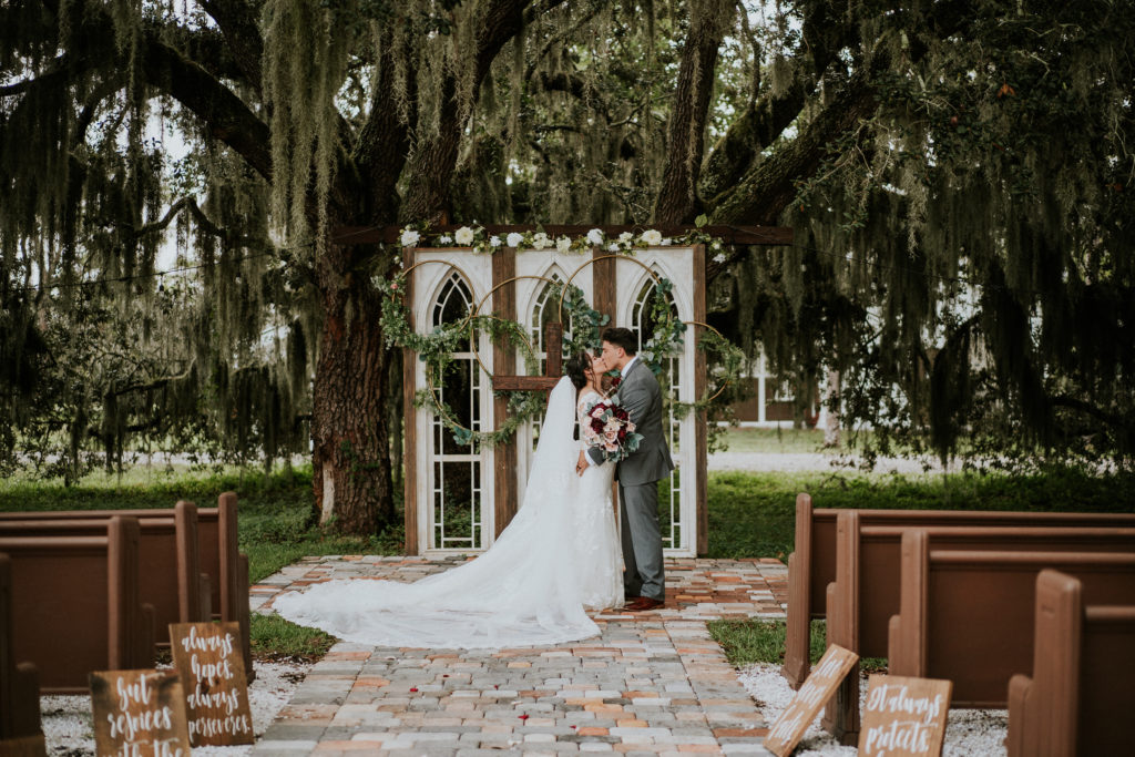 Ever After Farms Ranch Stuart Florida wedding ceremony kiss under Spanish moss tree