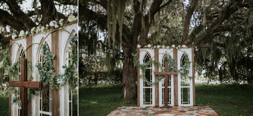 Ceremony white window backdrop wedding arbor with wood cross altar under a tree