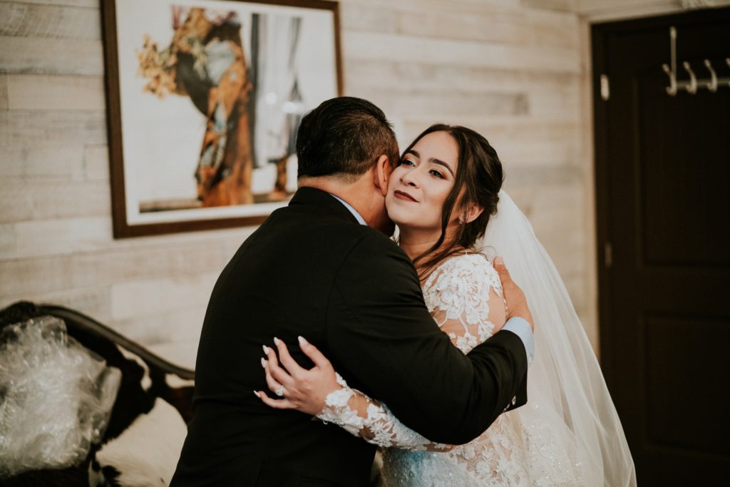 Dad hugs bride in bridal suite