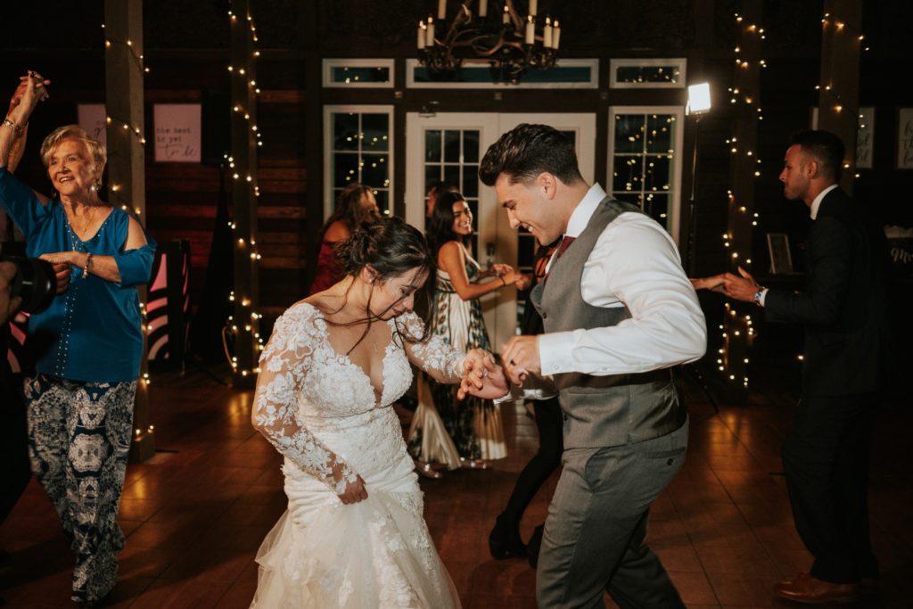 Bride and groom dance with fairy lights in the background at Ever After Farms Wedding Barn Florida venue