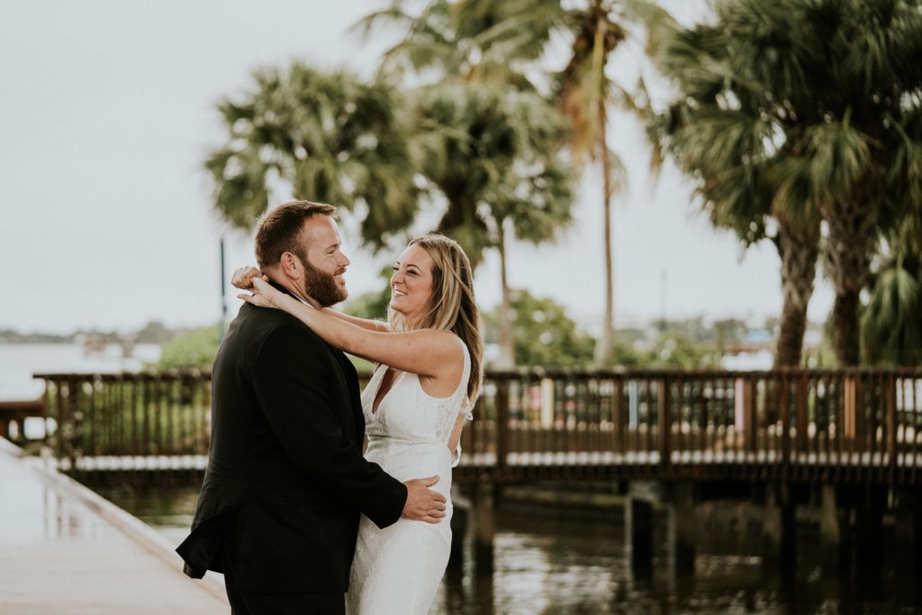 Bride and groom dance on Rockin' Riverwalk with palm trees in background in Downtown Stuart FL elopement