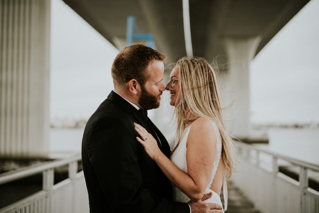 Bride and groom embrace for kiss under Roosevelt bridge in Downtown Stuart FL wedding