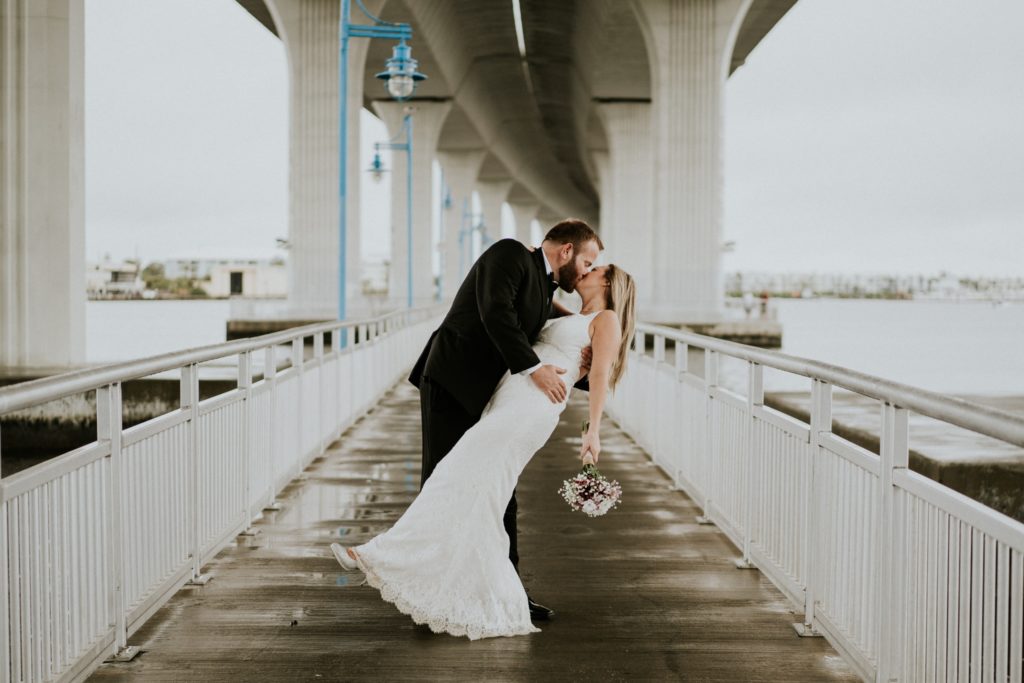 Bride and groom dip kiss under Roosevelt bridge in urban Downtown Stuart FL wedding