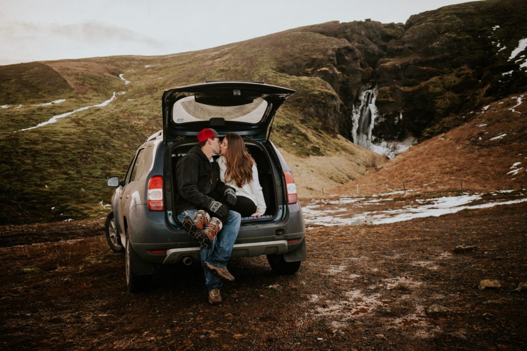 Iceland elopement couple kiss in the back of a van in waterfall landscape