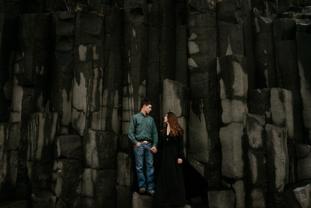 Iceland elopement couple standing on basalt columns at Reynisfjara Black Sand Beach