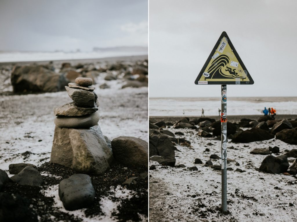 Stone cairn and danger wave warning sign on Reynisfjara Black Sand Beach Vík