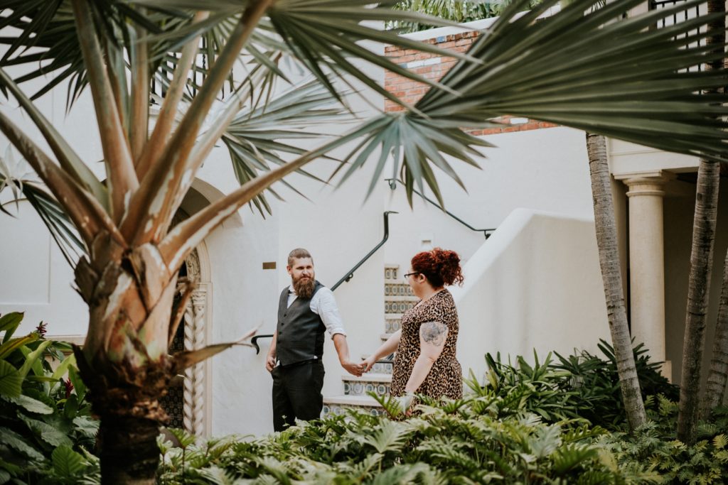 Engaged couple walks Worth Ave Palm Beach courtyard