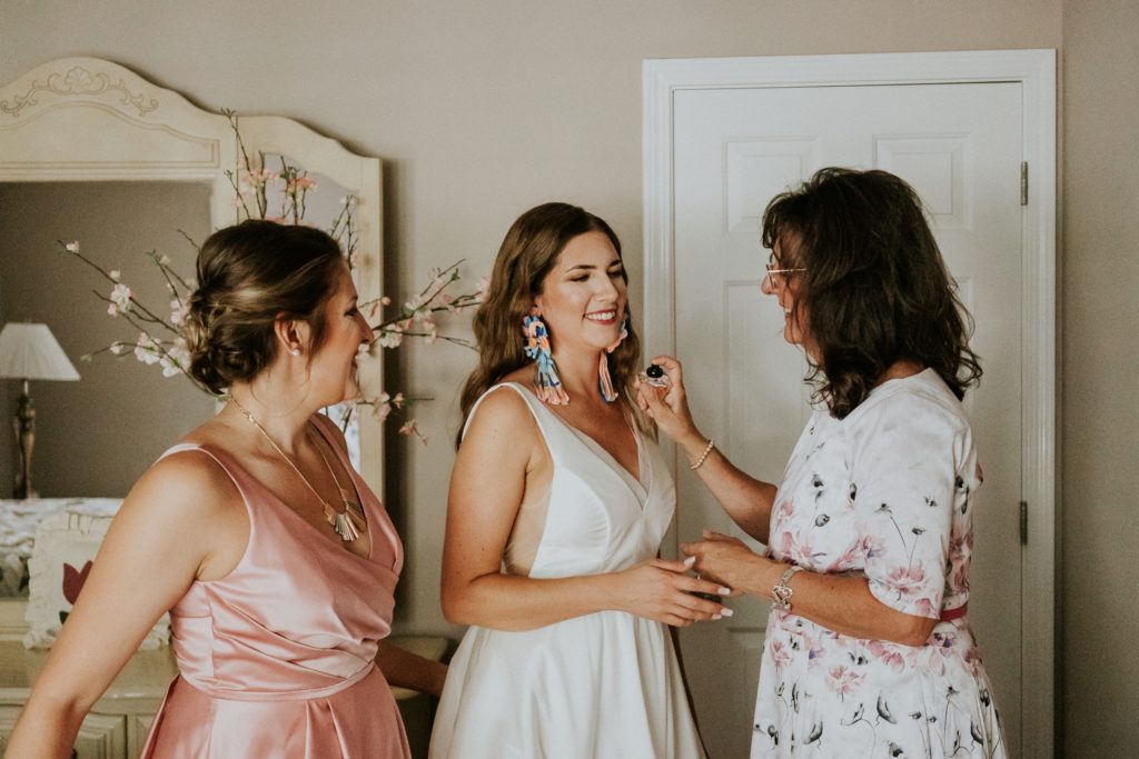 Mother of bride sprays perfume onto bride and daughter Atlanta GA backyard wedding Florida elopement photography
