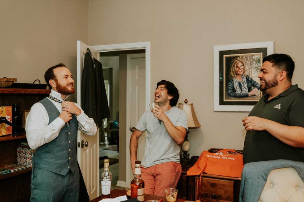 Groom and groomsmen laugh and get ready in Duluth GA at-home wedding