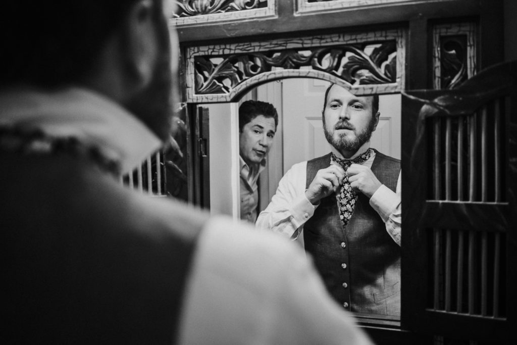 Groom fixes tie in mirror Duluth GA family home backyard wedding FL elopement photographer