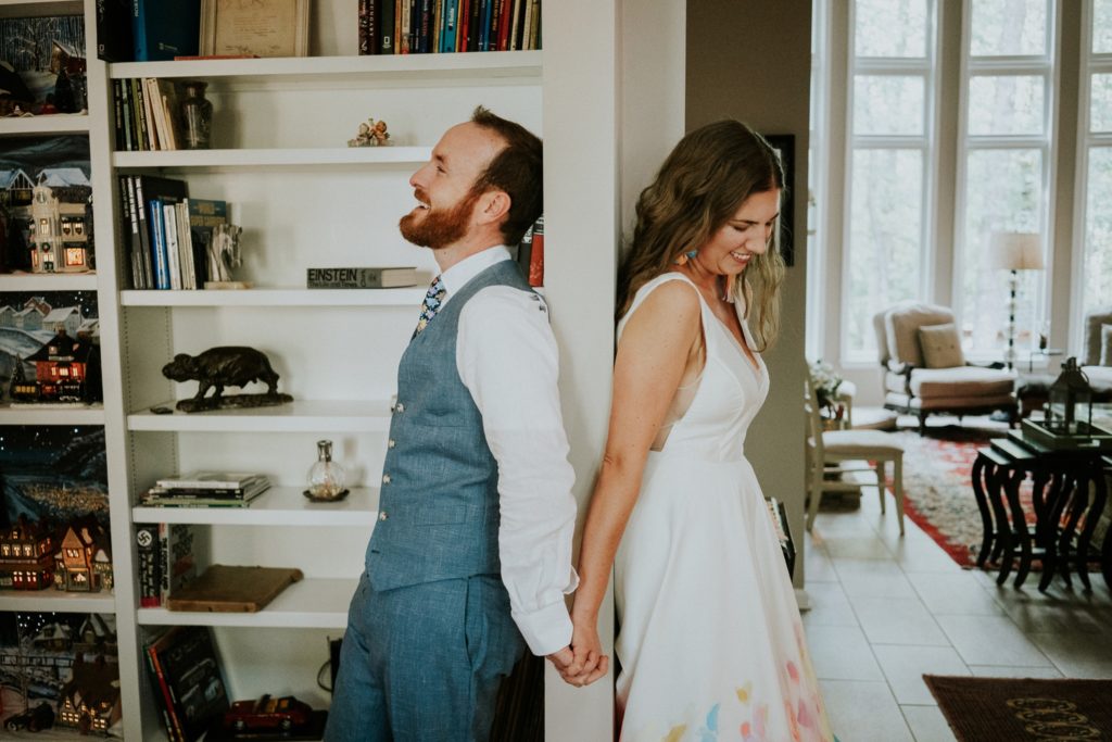 Bride and groom laugh during first touch at home wedding Atlanta GA FL elopement photographer