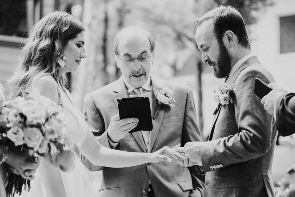 Groom puts ring on bride's finger during Duluth GA wedding ceremony