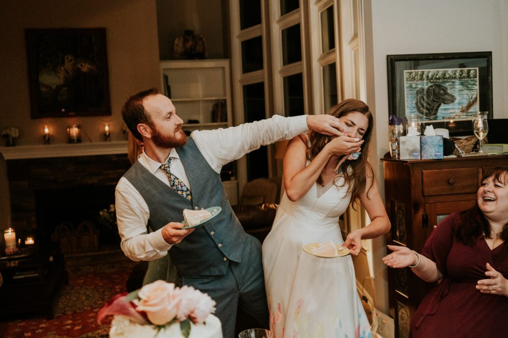 Groom feeds bride wedding cake at home backyard wedding Atlanta GA