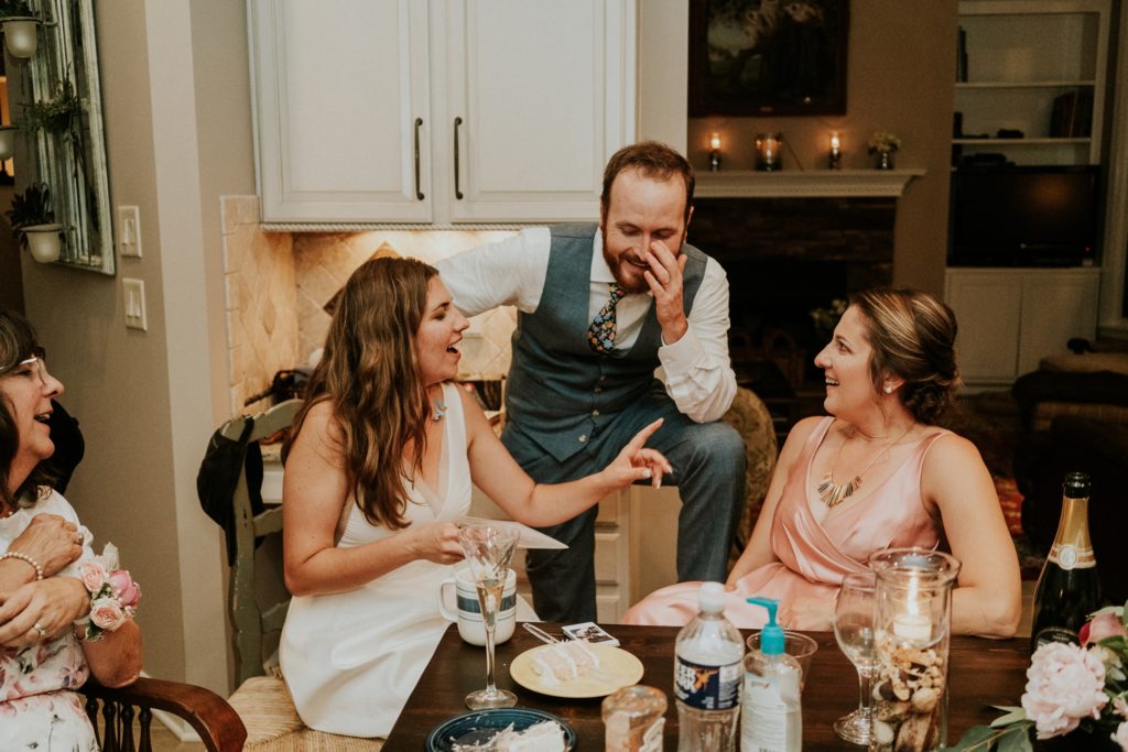 Bride and groom laugh with maid of honor at home wedding dinner Atlanta GA Florida elopement photography