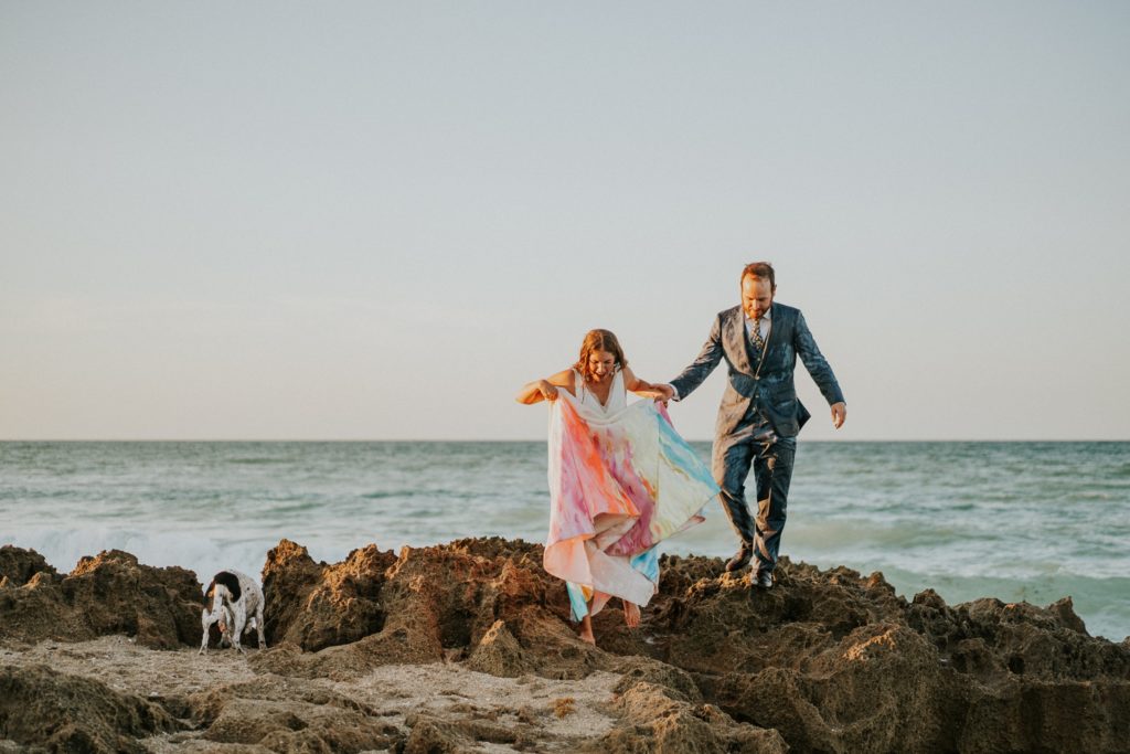 Bride and groom climb rocky beach Stuart FL elopement photography