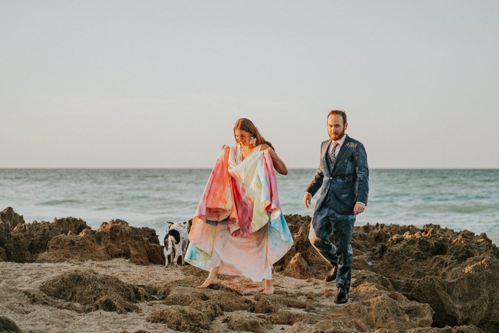 Bride and groom climb rocky beach Stuart FL elopement photographer