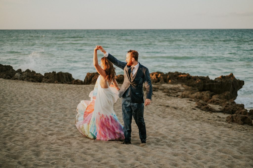 Bride and groom twirl dance on rocky beach Stuart FL elopement photography