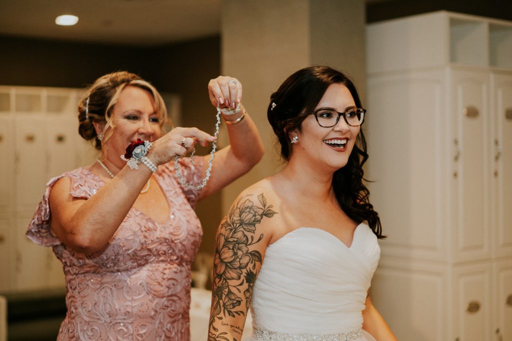 Mother of bride gives daughter necklace on wedding day