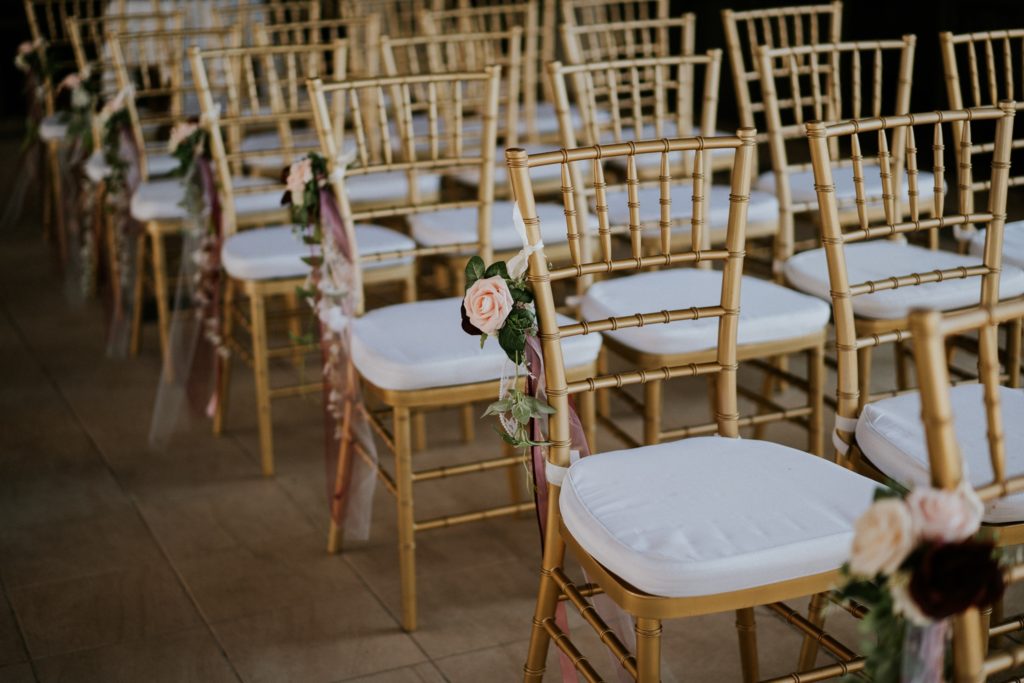 Gold chairs with pink flowers wedding ceremony decor