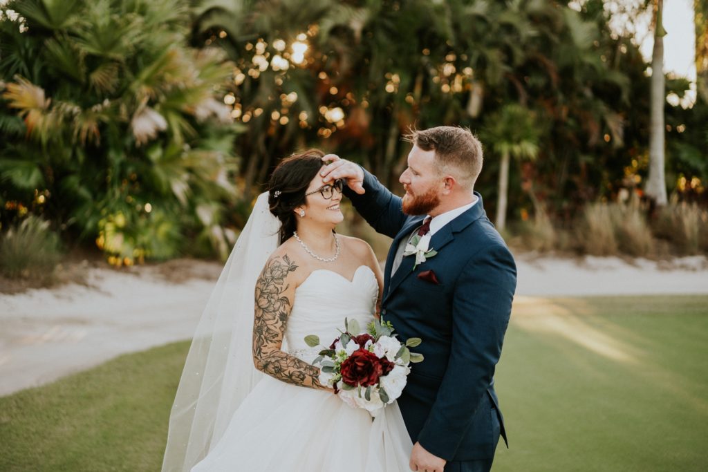 Groom touches tattooed bride's face