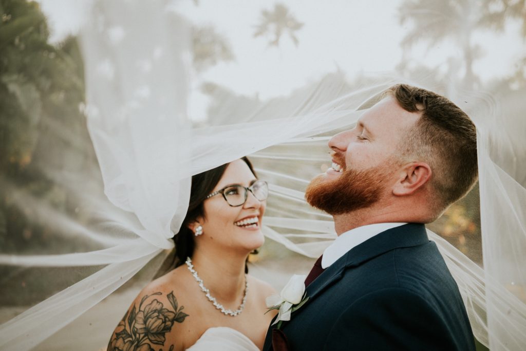 Bride with glasses and groom laughing under wedding veil Wanderers Club Wellington FL wedding photography