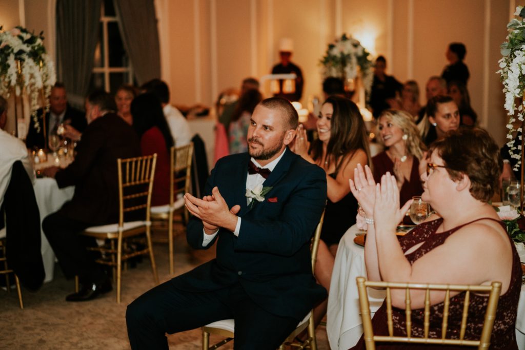 Wedding guests clap during reception toasts