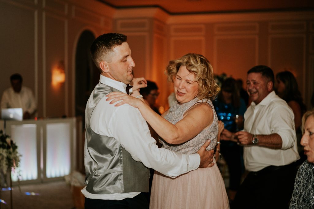 Groomsmen dances with mom wedding reception