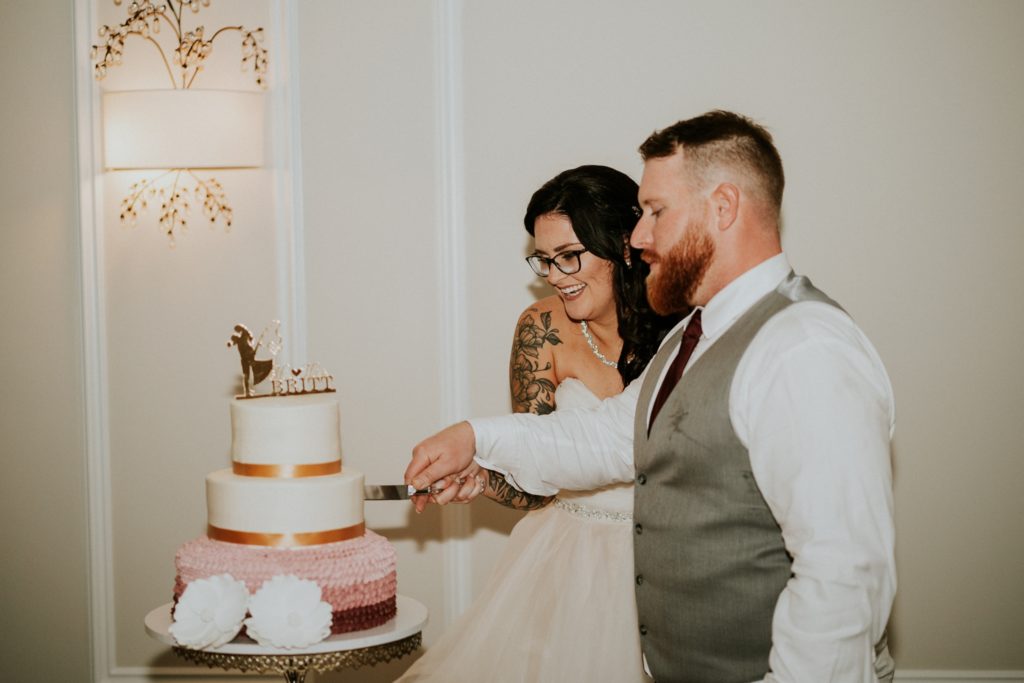 Bride and Groom cut pink red and white wedding cake
